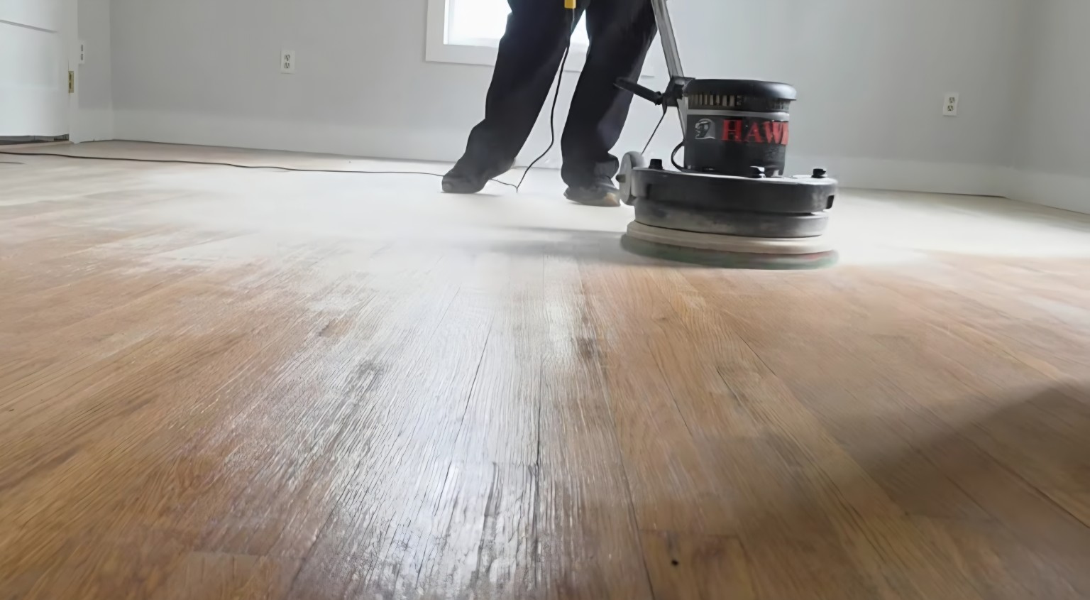 Low angle view of the hardwood floor being screened with a Hawk buffer